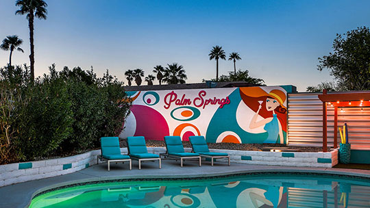 The Summit Palm Springs twilight pool view and mural.