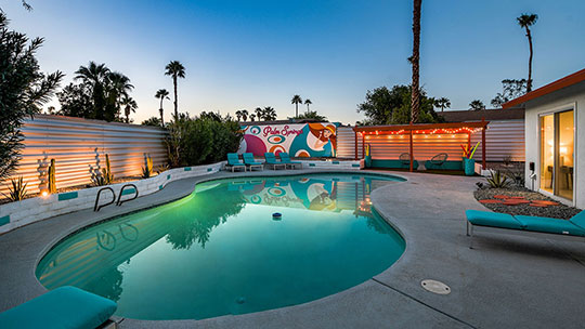 The Summit Palm Springs twilight view of oversize pool and lounge area.