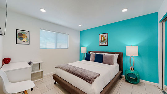 The Summit Palm Springs teal queen bedroom.